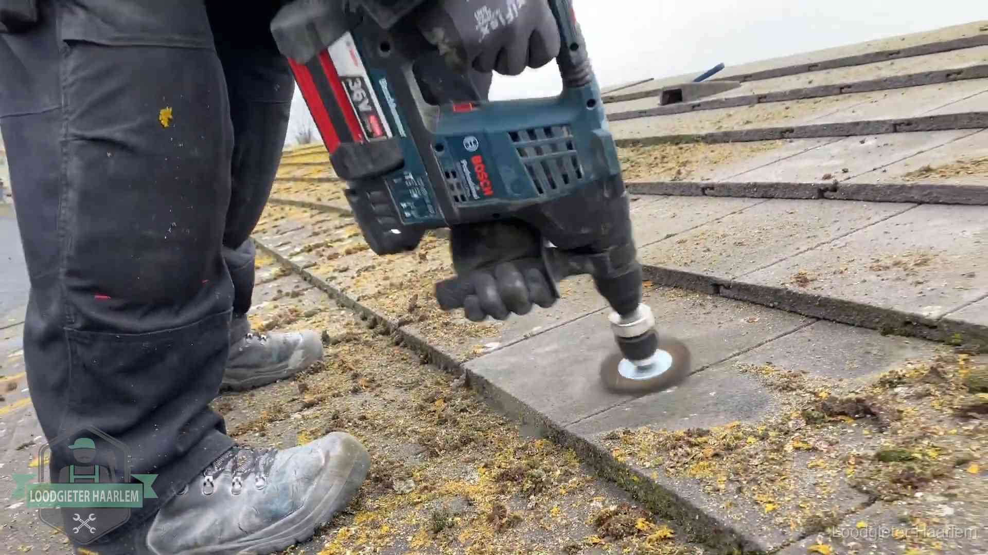 Betonnen dakpannen worden machinaal gereinigd tijdens dakonderhoud in Haarlem