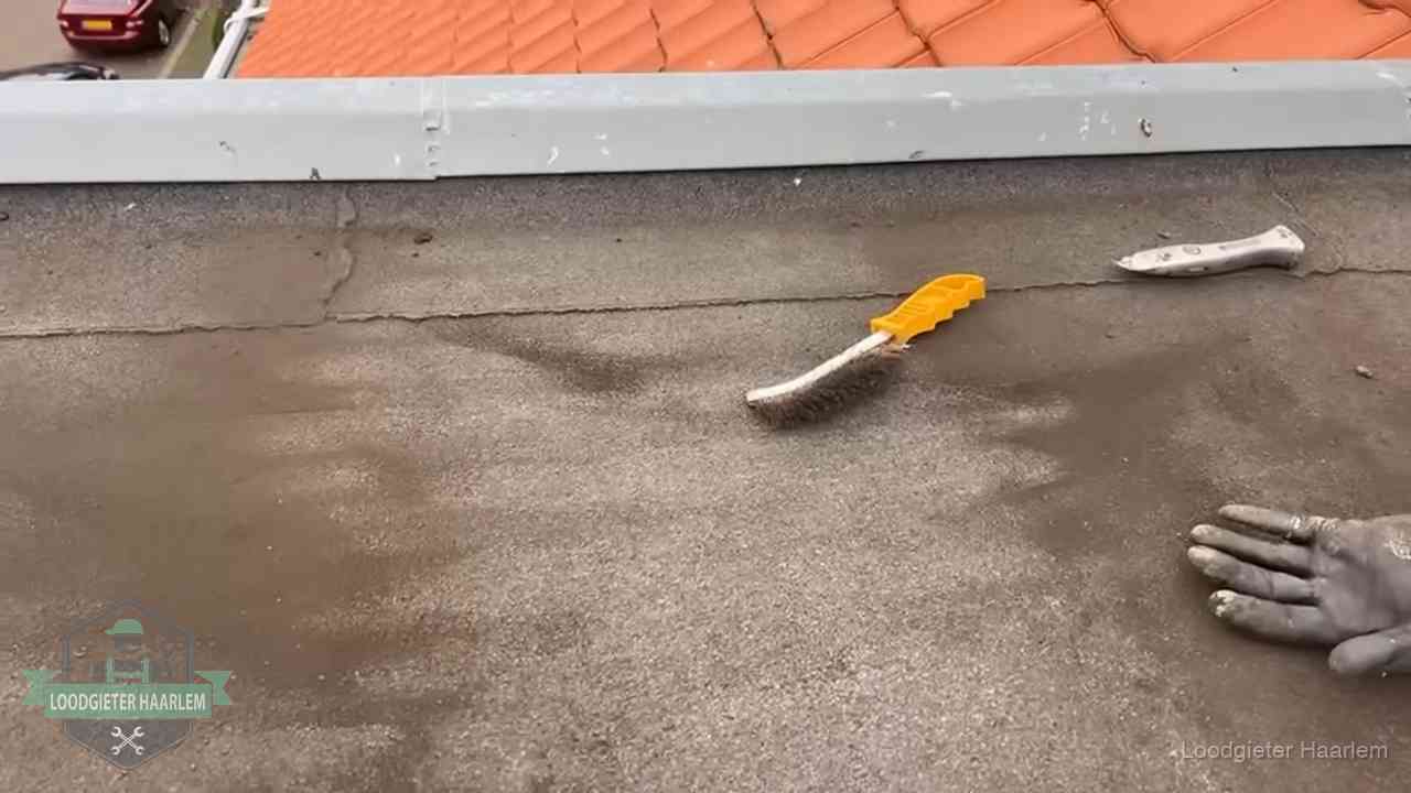 Dakdekker bereidt een bitumen plat dak voor op reparatie bij de daktrim in Haarlem