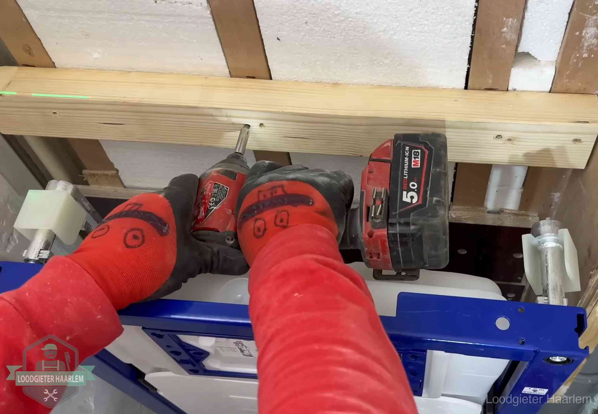 Monteur bevestigt een inbouwreservoir voor een hangend toilet in Haarlem