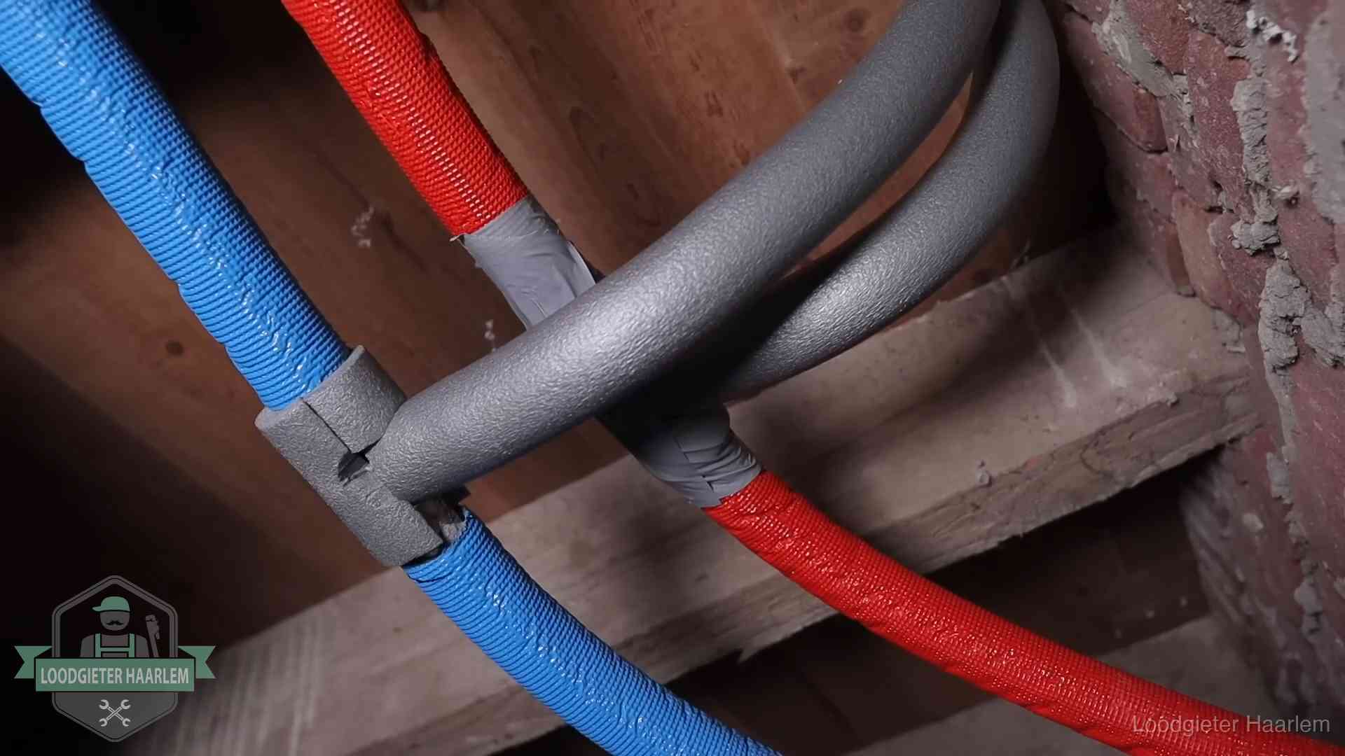 Geïsoleerde waterleidingen langs houten balken tegen bevriezing in Haarlem