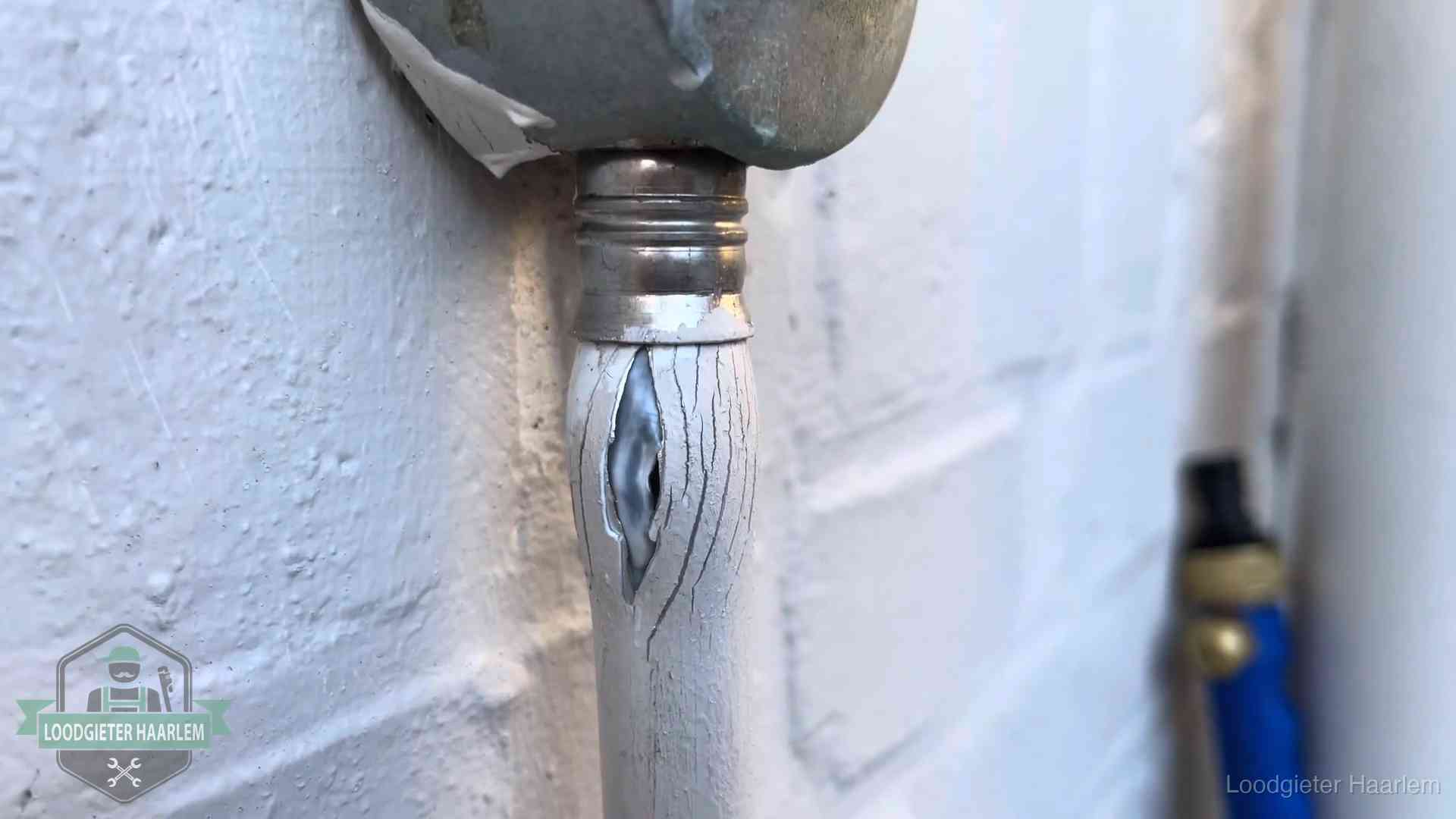 Oude waterleiding in Haarlem waar de verf openscheurt, een stille aanwijzing voor een beginnend lek