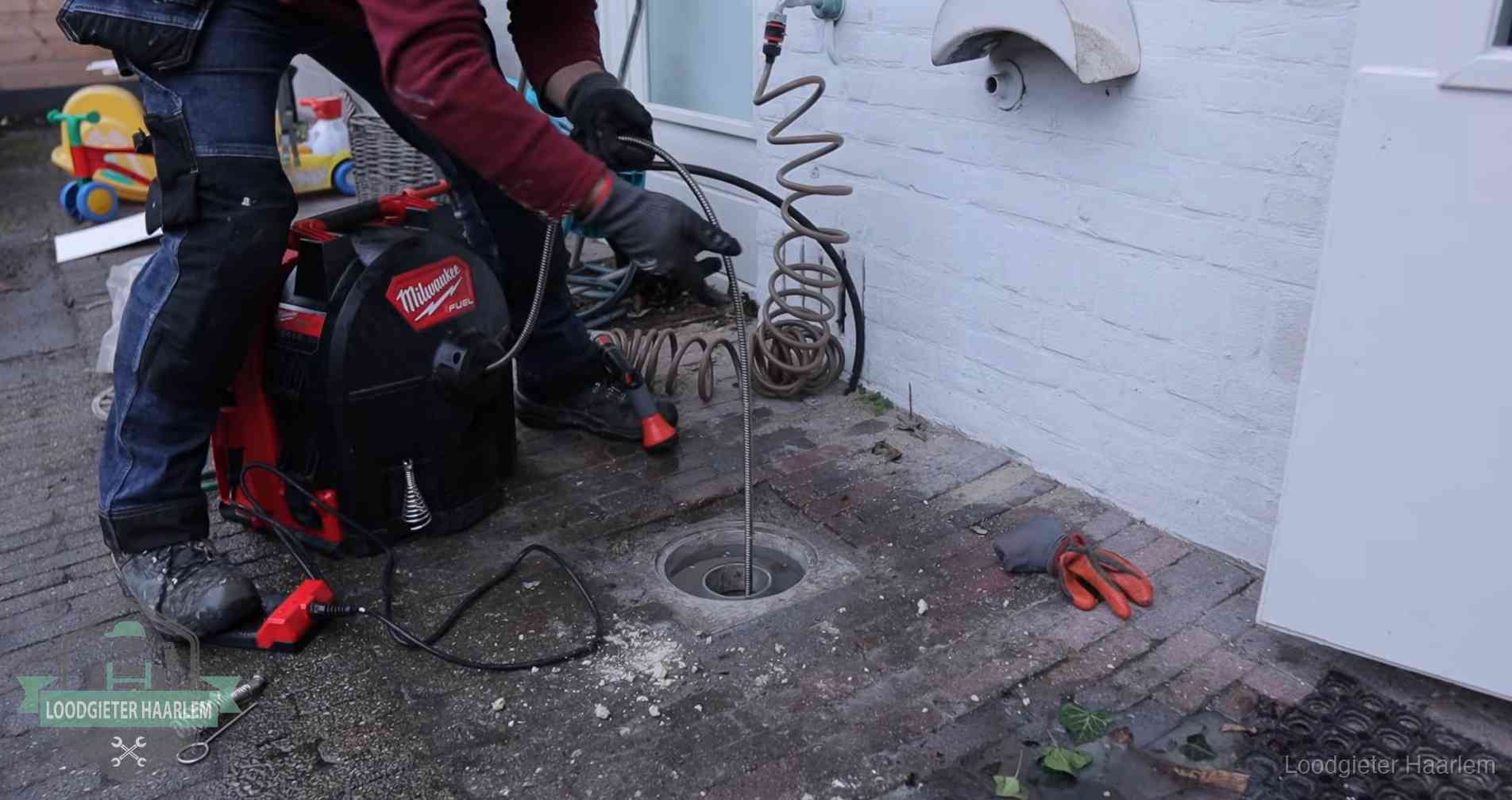 Erfgrens en gemeenteriool in Haarlem Ontstoppingsputje in de bestrating naast de gevel van een woning in Haarlem