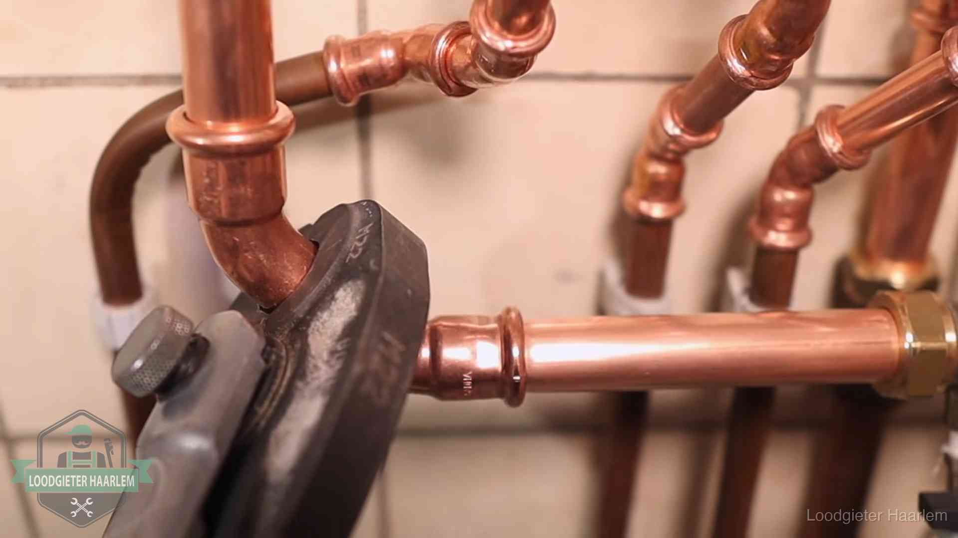 Werkwijze van ons loodgietersbedrijf in Haarlem Persmachine perst een koperen fitting op nieuw leidingwerk in Haarlem