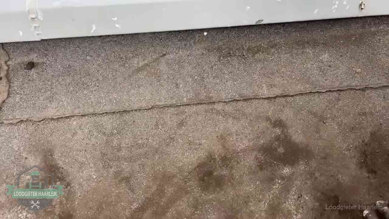 Vochtplekken bij de naad van een plat dak na aanhoudende regen in Haarlem