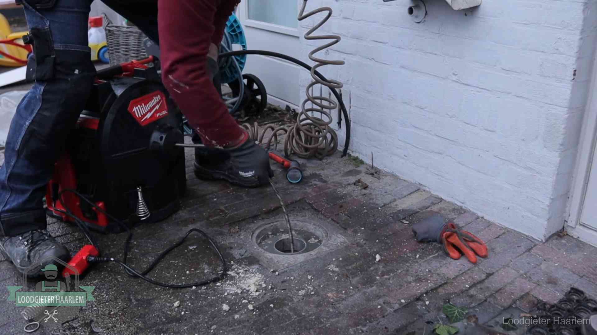 Prijs van een rioolontstopping in Haarlem Spiraalmachine bij een ontstoppingsputje in de bestrating in Haarlem