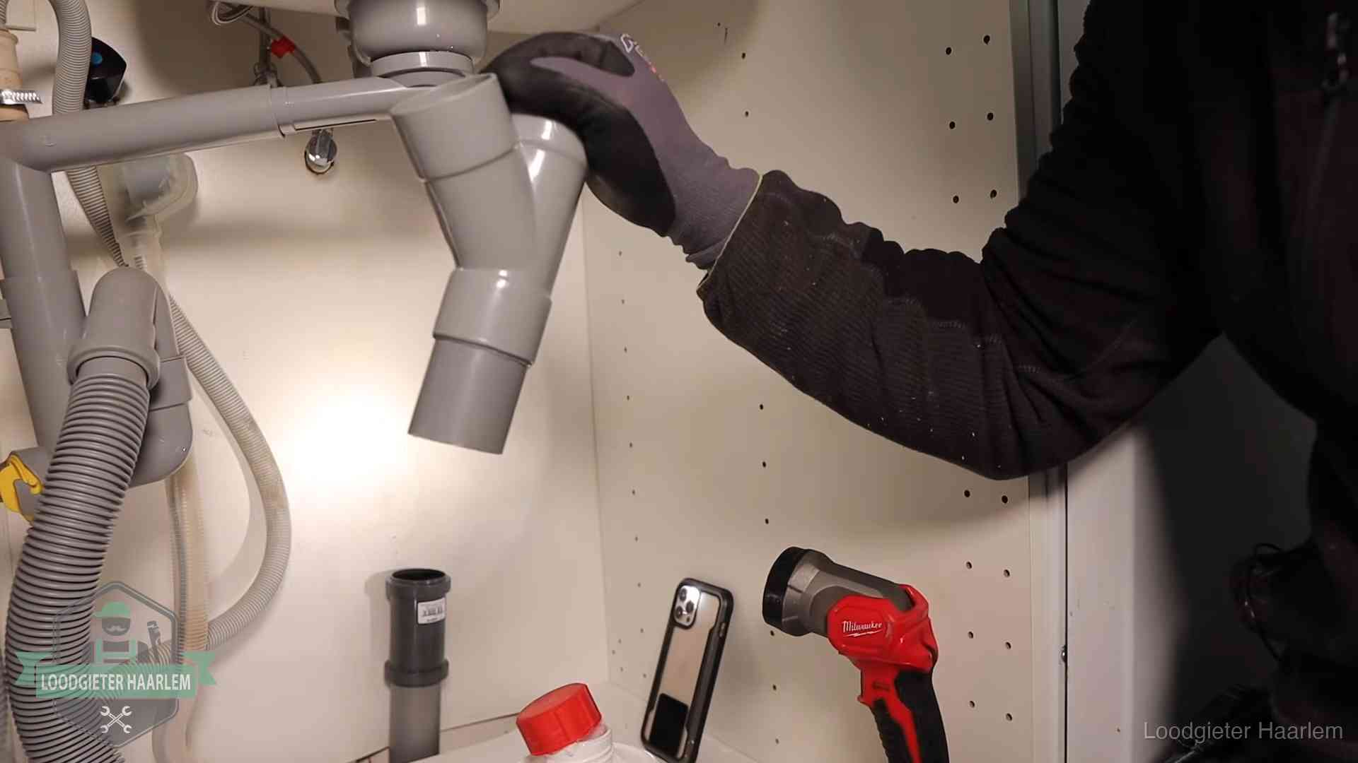 Rioollucht in huis verhelpen in Haarlem Loodgieter demonteert het sifon- en afvoerwerk onder een gootsteen in Haarlem bij stankklachten