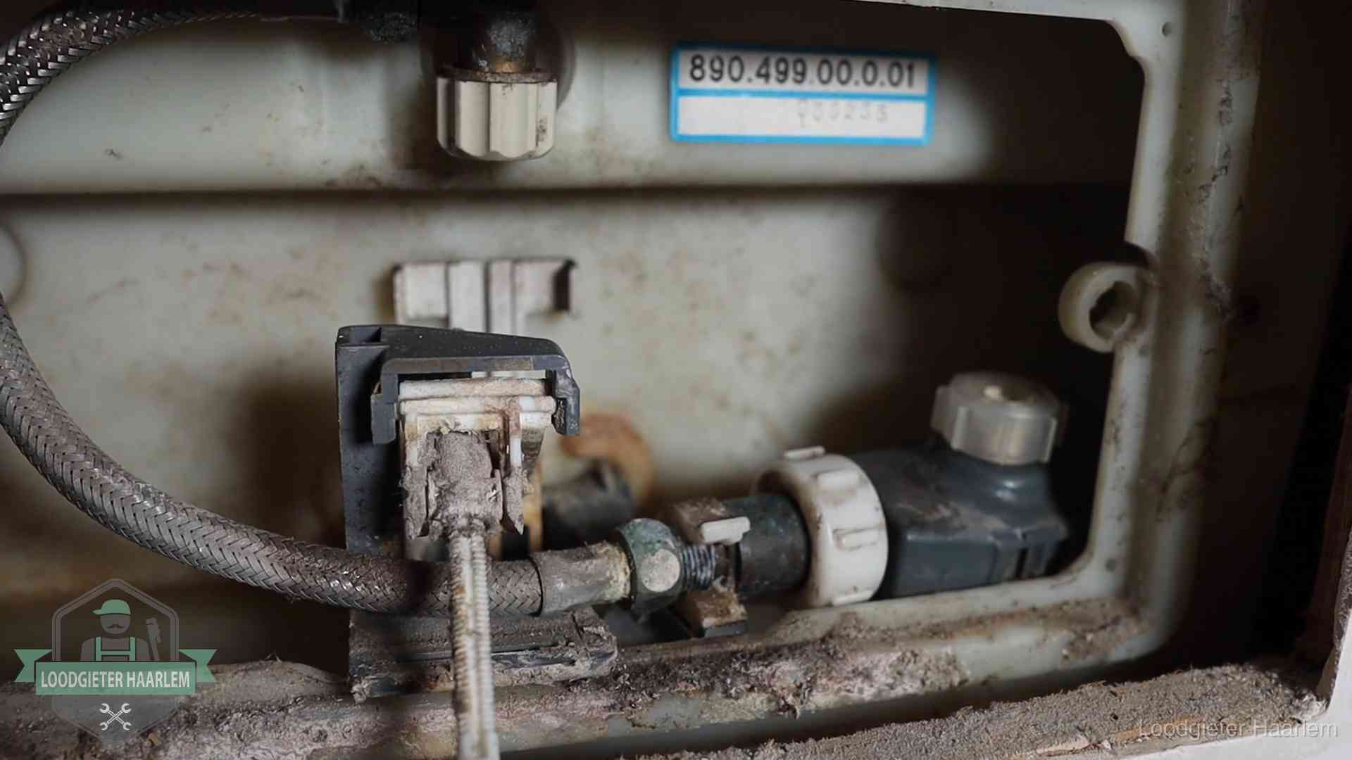 Verkalkt binnenwerk van een stortbak met vlotterkraan in Haarlem