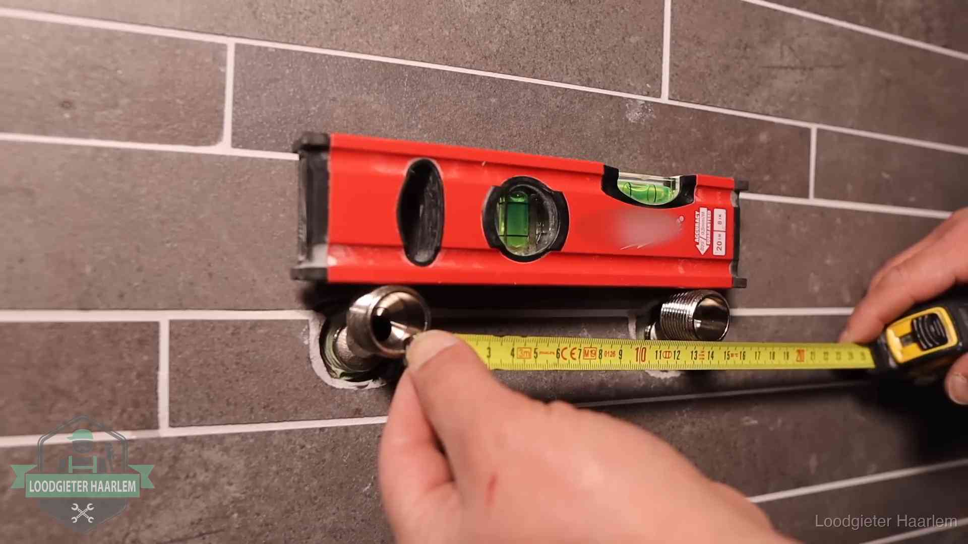 Waterpas en duimstok bij kraan-aansluitpunten in een badkamer in Haarlem