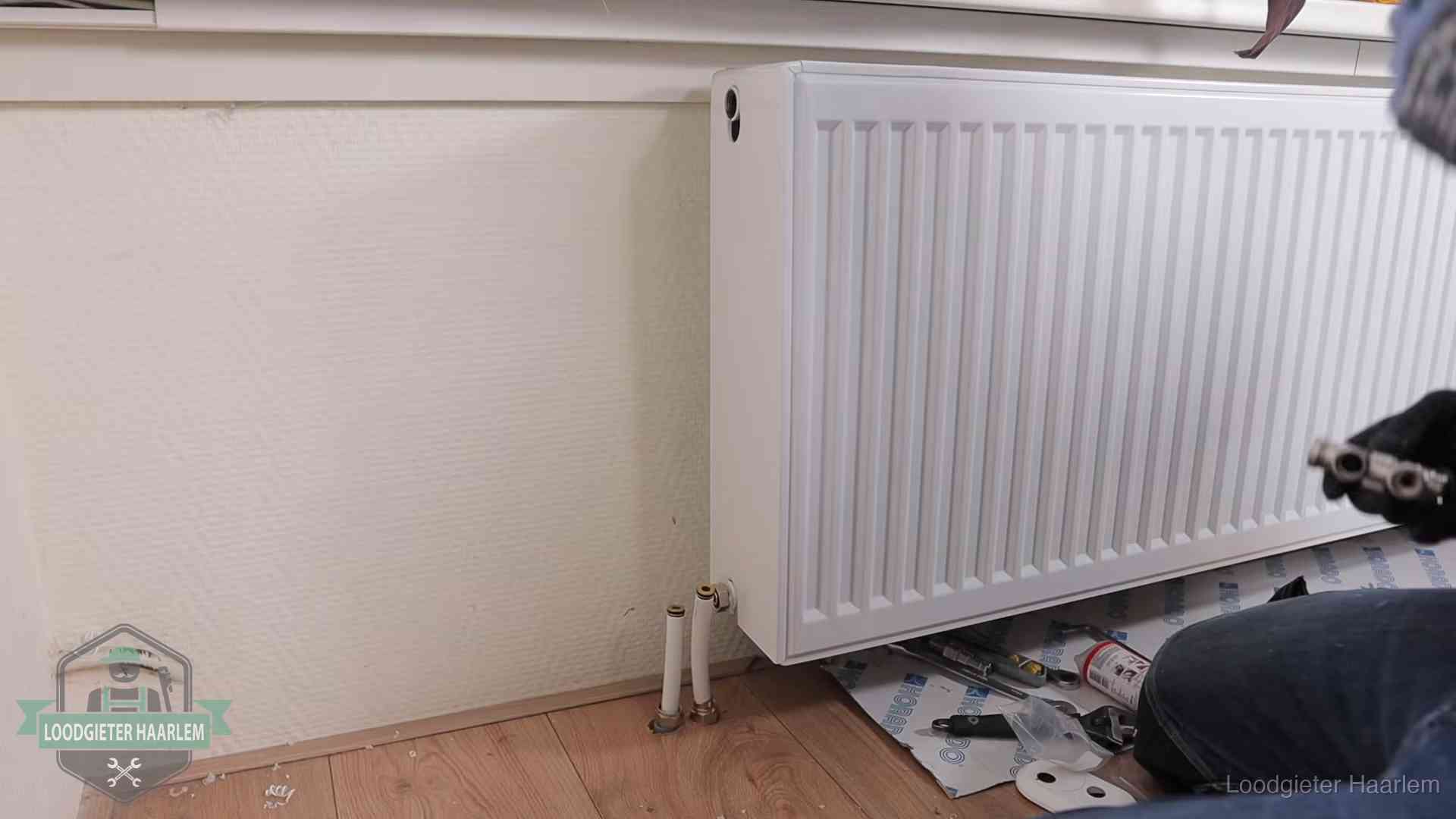 Verwarming per wijk in Haarlem Nieuw gemonteerde radiator in een woonkamer in Haarlem