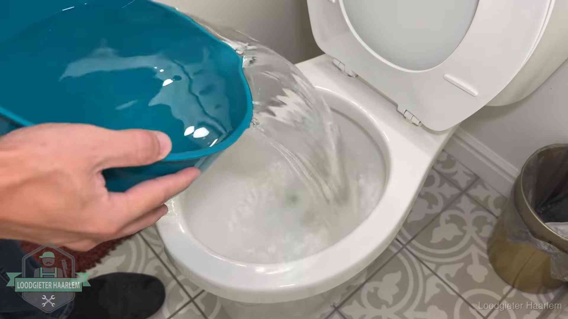 Warm water wordt voorzichtig in de wc-pot gegoten in Haarlem