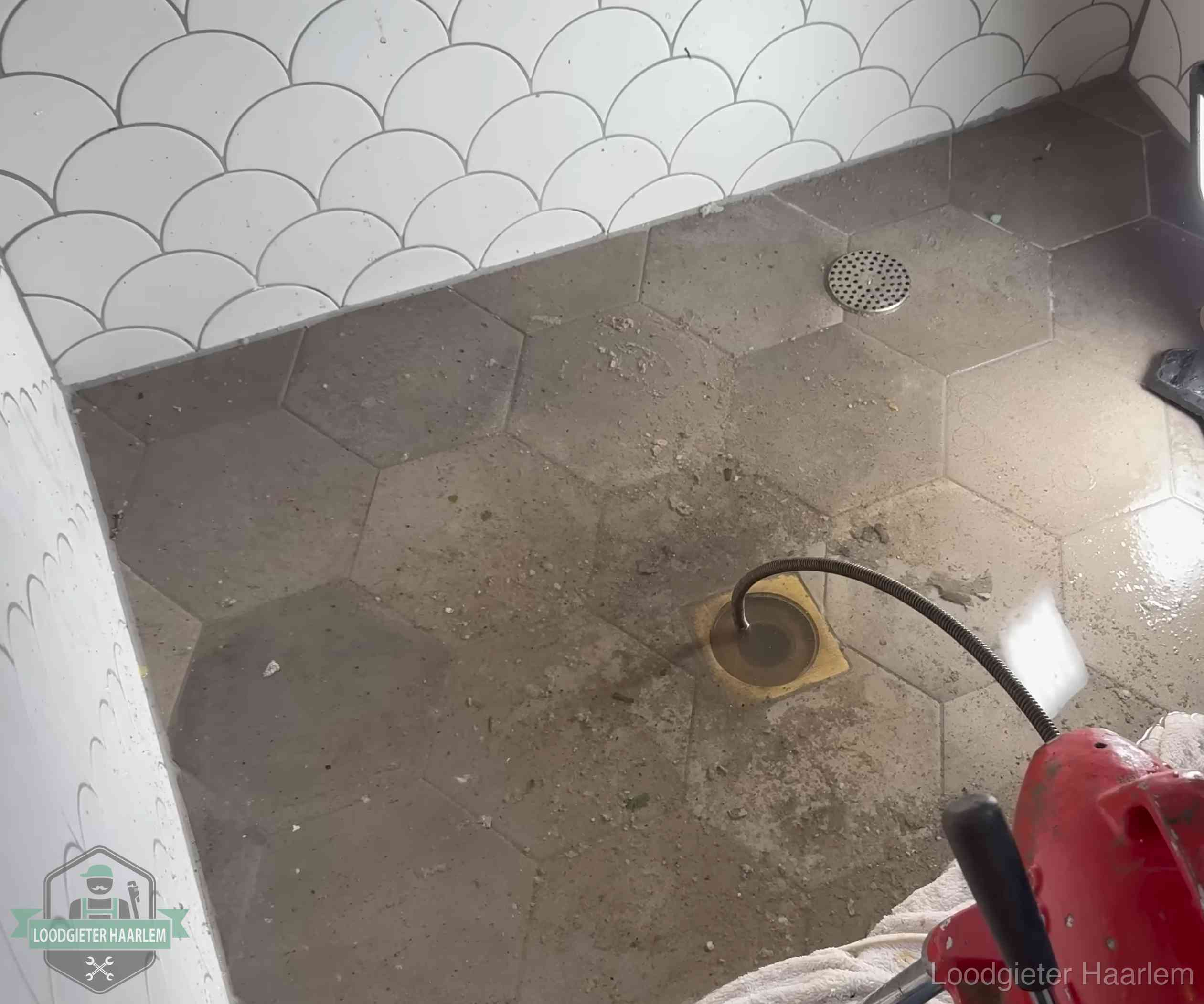 Vloerput met waterslot in een badkamer in Haarlem, een bron van stank als het waterslot droogstaat