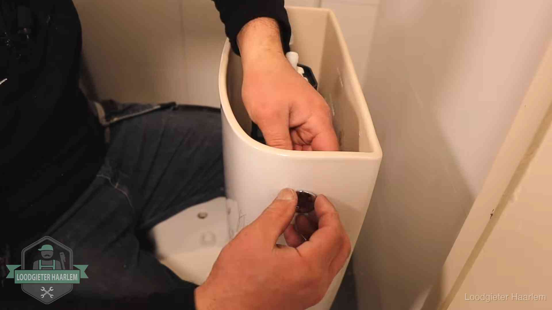 Drukknop van een duoblok-stortbak wordt gemonteerd bij een toilet in Haarlem