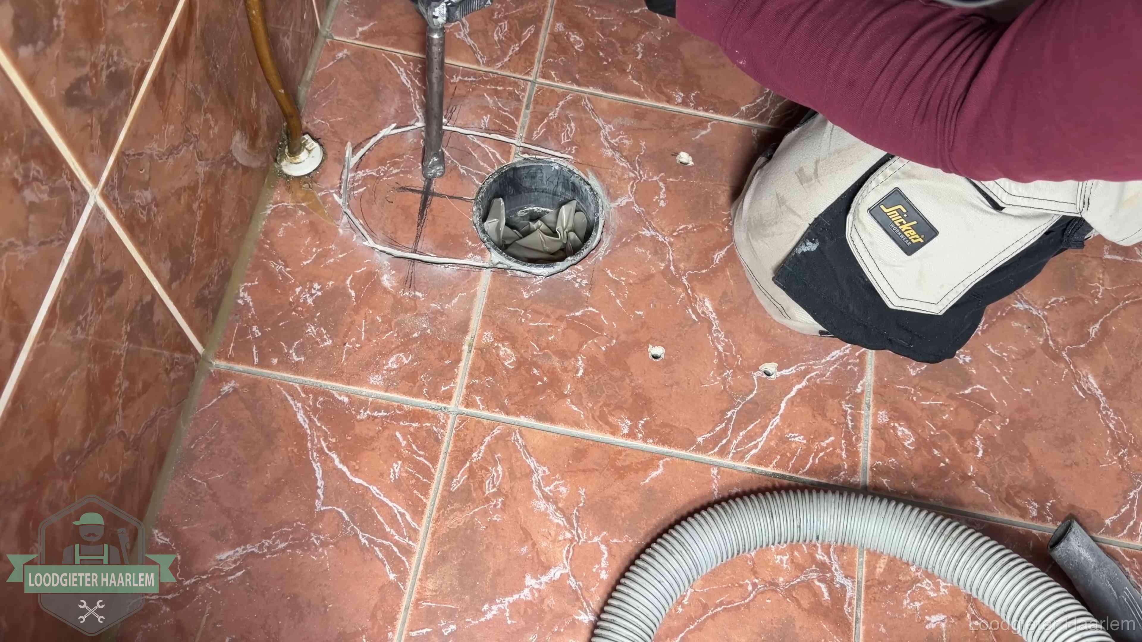 Open rioolaansluiting in de vloer waar de wc-pot is gedemonteerd in Haarlem